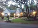 Evening view of single story home featuring landscape lighting and mature trees at 19811 Lake Dorr Rd, Altoona, FL 32702