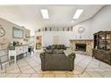 Spacious living room featuring high ceilings, skylights, stone fireplace, and tile flooring at 4346 Thomas Wood Ln E, Winter Haven, FL 33880