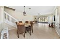 Open-concept dining room features tile floors, a modern light fixture, and views of the backyard at 6059 Twain St # 108, Orlando, FL 32835