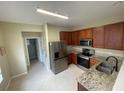 Modern kitchen featuring stainless steel appliances, wood cabinets, and granite countertops at 6059 Twain St # 108, Orlando, FL 32835