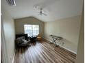 Cozy living room featuring vaulted ceiling, hardwood floors, and natural light at 6059 Twain St # 108, Orlando, FL 32835