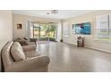 Spacious living room with tile flooring, large windows, and a sliding glass door offering natural light and outdoor views at 6059 Twain St # 108, Orlando, FL 32835