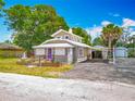 Quaint home with unique architecture, landscaping, driveway, and parking area at 70 N Oak Ave, Umatilla, FL 32784