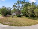 Charming single-story home featuring a well-maintained lawn, mature trees, and welcoming curb appeal at 994 Country Lake Cir, Lake Wales, FL 33898