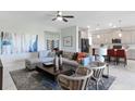Open concept living room with modern decor and seamless flow into the kitchen at 4842 Waltham Forest Dr, Davenport, FL 33837