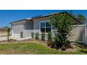 Well-maintained front yard with lush grass, decorative shrubs, and a concrete walkway leading to the house at 8007 Sw 135Th Loop, Ocala, FL 34473