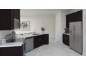Modern kitchen with sleek countertops, stainless steel appliances, and dark cabinets at 2115 Forage Dr, Kissimmee, FL 34746