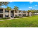 Exterior of a two-story condo complex with well-kept green lawn and mature palm trees at 4014 Hemingway Cir # 4014, Haines City, FL 33844