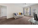 A cozy living room features natural light from the window and a comfortable couch with a ceiling fan at 4014 Hemingway Cir # 4014, Haines City, FL 33844
