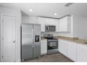 Modern kitchen with stainless steel appliances, white cabinets, and granite countertops at 1 Zinnia E Ln, Poinciana, FL 34759