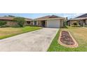 Exterior view showing the driveway leading to an attached garage and manicured lawn at 492 Caribbean Dr, Lakeland, FL 33803