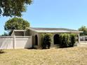 View of back exterior showing white fence and mature landscaping at 2201 Flamingo Ave, Deltona, FL 32738
