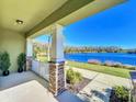 Inviting porch with a peaceful lake view, framed by lush greenery and blue skies at 9971 Highland Sky Aly, Orlando, FL 32832