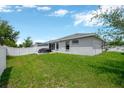 Spacious backyard with lush green grass, white fence, and patio area, perfect for outdoor activities and relaxation at 305 St Georges Cir, Eagle Lake, FL 33839