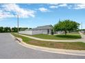 View of gray home with a white fenced yard and well-manicured lawn on a corner lot at 305 St Georges Cir, Eagle Lake, FL 33839