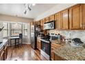 Efficient kitchen with stainless steel appliances, granite counters, and ample wood cabinets at 7759 Sugar Bend Dr # 7759, Orlando, FL 32819