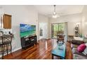 Bright living room features hardwood floors, a ceiling fan, and sliding glass doors to the balcony at 7759 Sugar Bend Dr # 7759, Orlando, FL 32819
