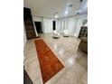 Spacious living room with tile flooring, staircase, and two white accent chairs at 1030 Marcello Blvd, Kissimmee, FL 34746