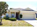 Charming single-story home with a two-car garage and well-maintained lawn and neutral exterior at 1886 Van Gogh Dr, Auburndale, FL 33823