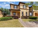 Charming two-story home with stucco exterior, dark shutters and landscaped front yard with brick pathway at 140 Napoli Dr, Davenport, FL 33897