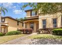 Charming two-story home with stucco exterior and landscaped front yard with brick pathway at 140 Napoli Dr, Davenport, FL 33897