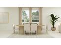 Elegant dining room featuring a modern table with seating for four, complemented by natural light from the large windows at 4536 Ochos Rios Pl, Kissimmee, FL 34758