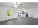 Open-concept living room next to a kitchen and featuring modern grey flooring at 576 Bay Leaf Dr, Poinciana, FL 34759