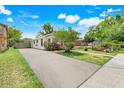 View of the side of the home with a long driveway and landscaping at 830 Polk St, Orlando, FL 32805