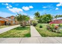Charming single-story home with a well-manicured lawn and colorful landscaping at 830 Polk St, Orlando, FL 32805