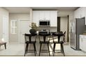 Modern kitchen featuring white cabinets, stainless steel appliances, and a breakfast bar with seating at 2879 Transformation Way, Clermont, FL 34714