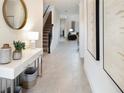 Inviting foyer with neutral floors, modern decor, console table, and staircase leading to the upper level at 3008 Protagonist St, Kissimmee, FL 34746