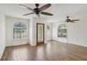 Bright living room featuring unique arched windows, wood-look tile floors, textured walls, and ceiling fans at 520 Hamlet Dr, Port Orange, FL 32127