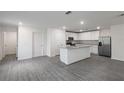 Bright, open-concept kitchen features white cabinets, granite countertops, and stainless steel appliances at 600 Bay Leaf Dr, Poinciana, FL 34759