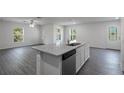 Kitchen island with stainless steel sink and appliances, complemented by ample natural light at 600 Bay Leaf Dr, Poinciana, FL 34759
