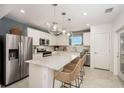 Modern kitchen featuring stainless steel appliances, white cabinets, pendant lighting, and center island with seating at 6780 Sw 90Th Loop, Ocala, FL 34476