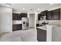 Modern kitchen with stainless steel appliances, dark cabinetry, and granite countertops at 1101 Pavia Dr, Apopka, FL 32703