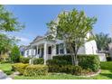 Beautiful home with a classic white exterior, a charming porch, and lush landscaping, offering curb appeal and tranquility at 14563 Bahama Swallow Blvd, Winter Garden, FL 34787