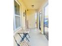Inviting front porch featuring neutral paint, a seating area, welcome decor and an outdoor security camera at 159 Lazy Willow Dr, Davenport, FL 33897