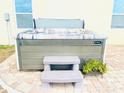 Hot tub with steps situated on a brick patio for relaxing, with lush planter nearby at 159 Lazy Willow Dr, Davenport, FL 33897