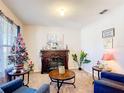 Cozy living room features a decorative fireplace, comfortable seating, and plenty of natural light at 159 Lazy Willow Dr, Davenport, FL 33897