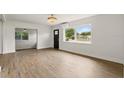 Bright living room with hardwood floors, a large window overlooking the front yard, and an open doorway at 2013 Pineway Dr, Orlando, FL 32839