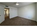 A bright bedroom with a ceiling fan, carpeted floors, and a double door closet at 568 Bahia Cir # B, Ocala, FL 34472