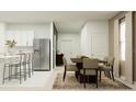 Open-concept dining area next to the kitchen with stainless steel appliances and a table that seats six at 7558 Headwaters Ct, Groveland, FL 34736