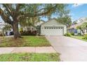 Charming single-story home with a two-car garage, mature landscaping, and a lovely shade tree at 13219 Meadowlark Ln, Orlando, FL 32828