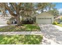 Charming one-story home with a two-car garage, mature landscaping, and a beautiful mature tree at 13219 Meadowlark Ln, Orlando, FL 32828