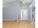Bright living room with high ceilings, modern gray walls, and light wood flooring and a decorative front door at 13219 Meadowlark Ln, Orlando, FL 32828