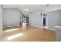 Bright living room with high ceilings, modern gray walls, and light wood flooring overlooking the kitchen at 13219 Meadowlark Ln, Orlando, FL 32828