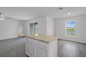 Open-concept kitchen with granite island, tile flooring, and a view of the backyard at 354 Bowfin Ct, Poinciana, FL 34759