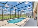 Relaxing screened-in pool with an attached jacuzzi and a view of the lush green backyard at 7634 Oakmoss Loop, Davenport, FL 33837