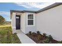 The house has a black front door, a small garden, and a concrete sidewalk at 2530 Linda Knoll Ln, Bartow, FL 33830
